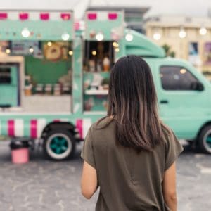 Young asian woman walking in the food truck market